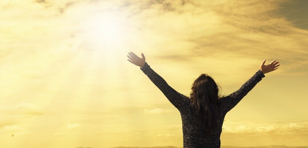 woman with wide open arms to the sun